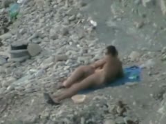 Auburn pallid chick lies on her stomach during the time that being pushed on cobble-stone beach